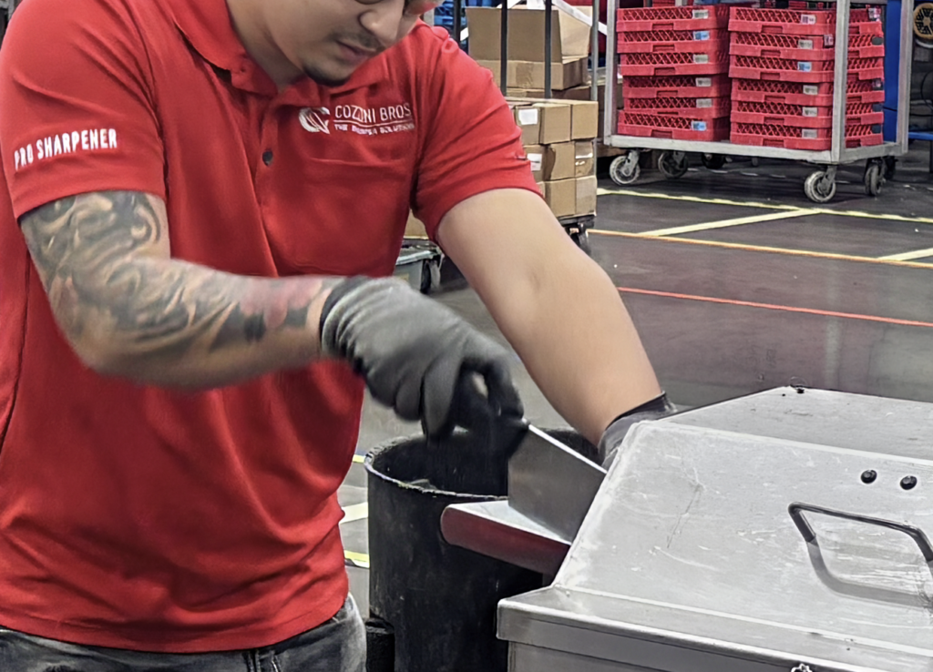 Cozzini technician sharpening knives at a sharpening center Cozzini technician sharpening knives at a sharpening center