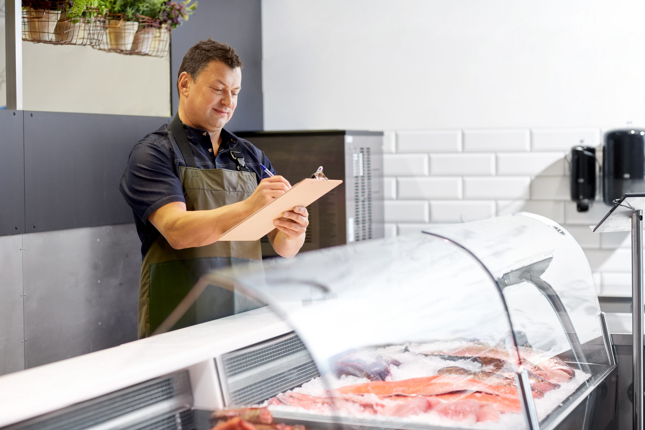 Seller managing inventory at a seafood counter